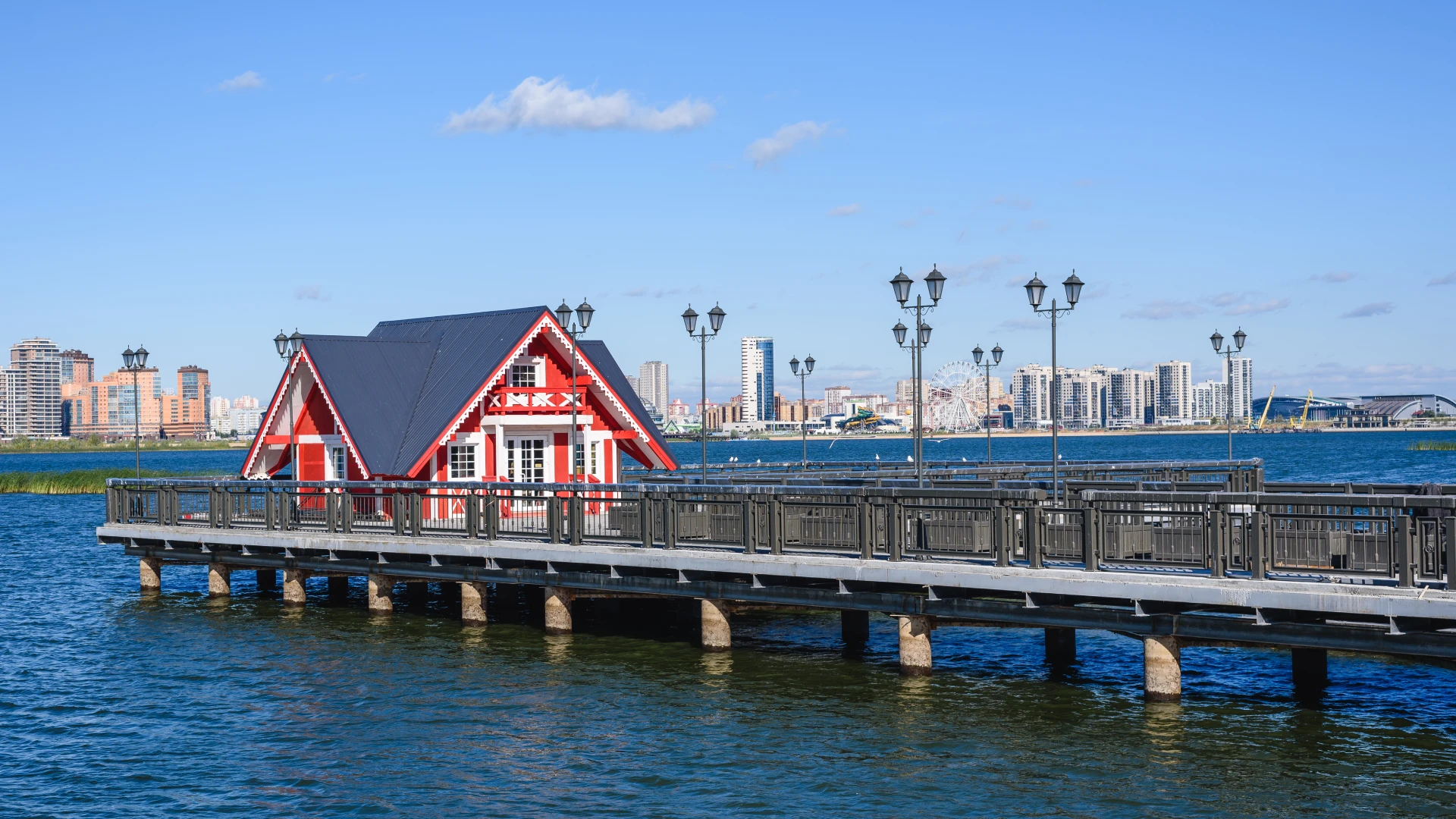 dock-with-black-metal-railing-and-the-beautiful-red-white-house-in-the-seattle-wa