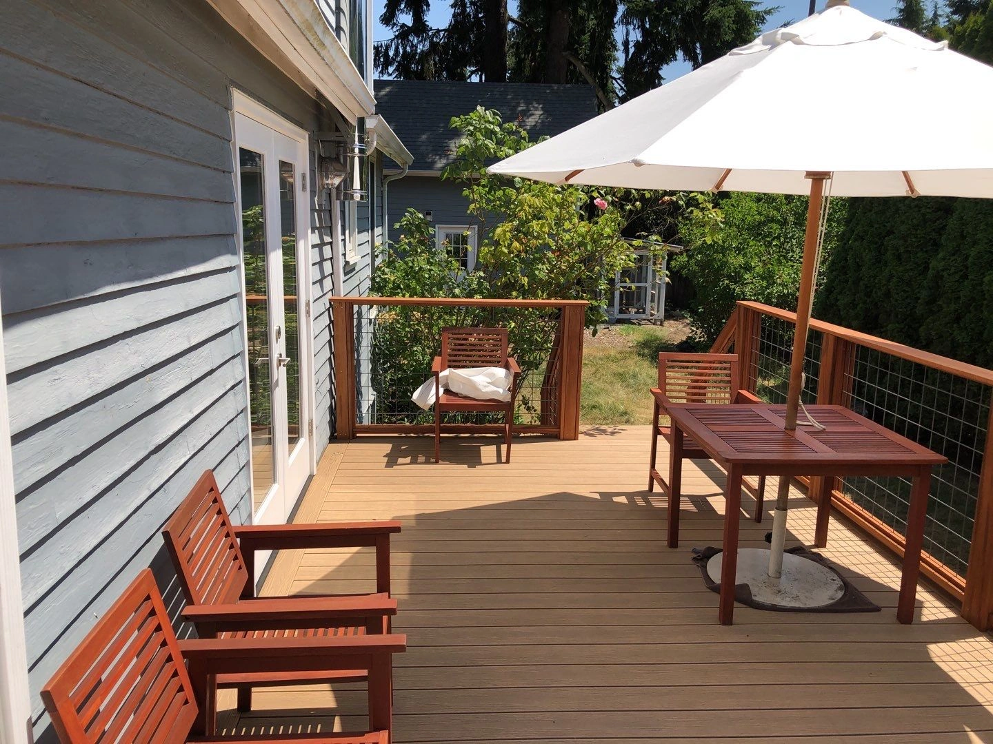 residential-deck-with-wooden-furniture-and-wire-mesh-railing